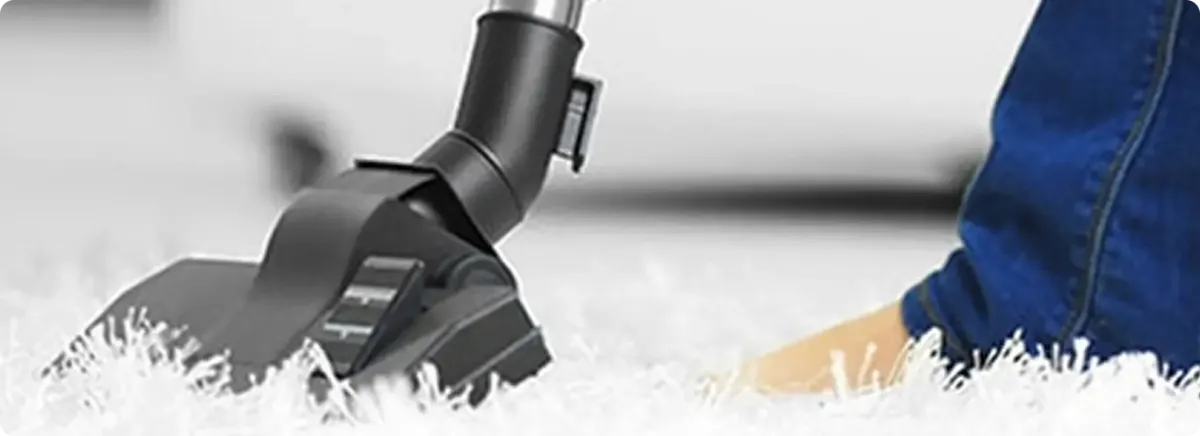 Close-up of a professional vacuuming a white carpet in Pleasant Hill.